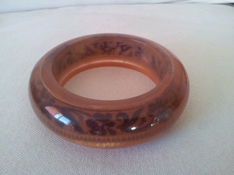 Brazalete de acrílico en color marrón de forma irregular con tela interior del mismo color y diseño de mármol