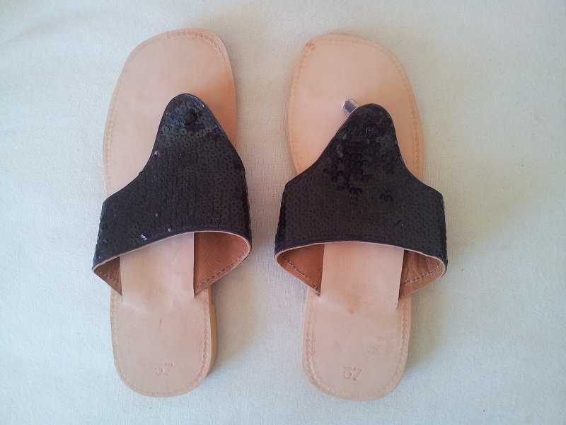 Sandalia plana para mujer en color negro con suela de piel y detalles de fantasía